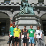 A group of teens with ASD stand infront of a statue of Queen Victoria in NYC as a part of their New York Aspergers program for Beyond Akeela